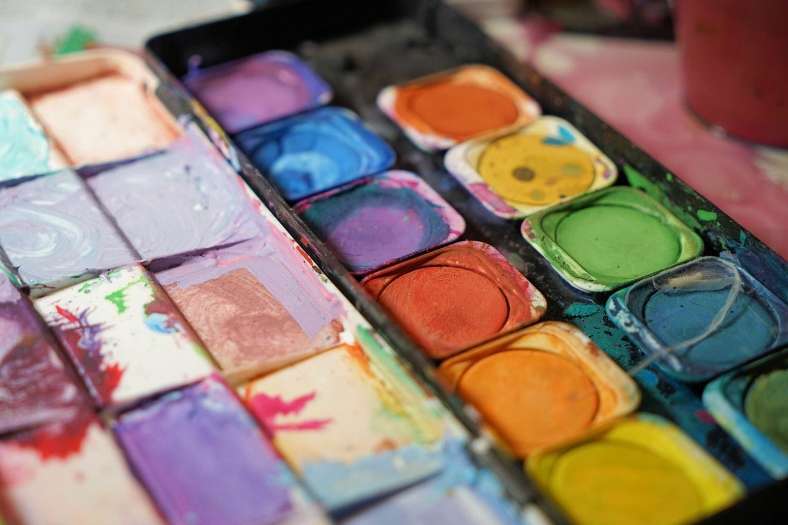 Carnet de voyage ouvert sur une page illustrée à l'aquarelle avec palette de peinture