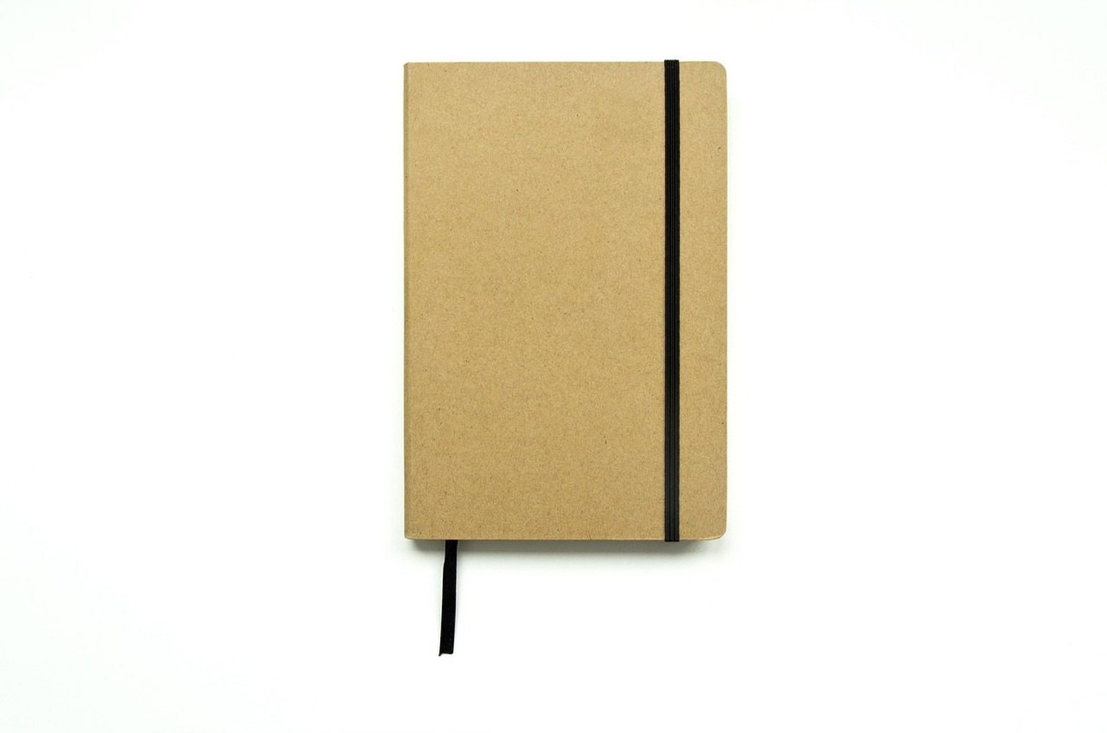 Carnet de voyage relié en cuir, posé ouvert sur une table de bois